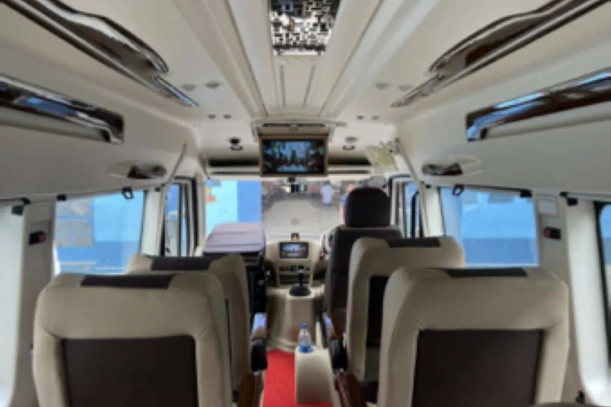 Inside the Tempo Traveller: individual reclining seats, curtains and standing height